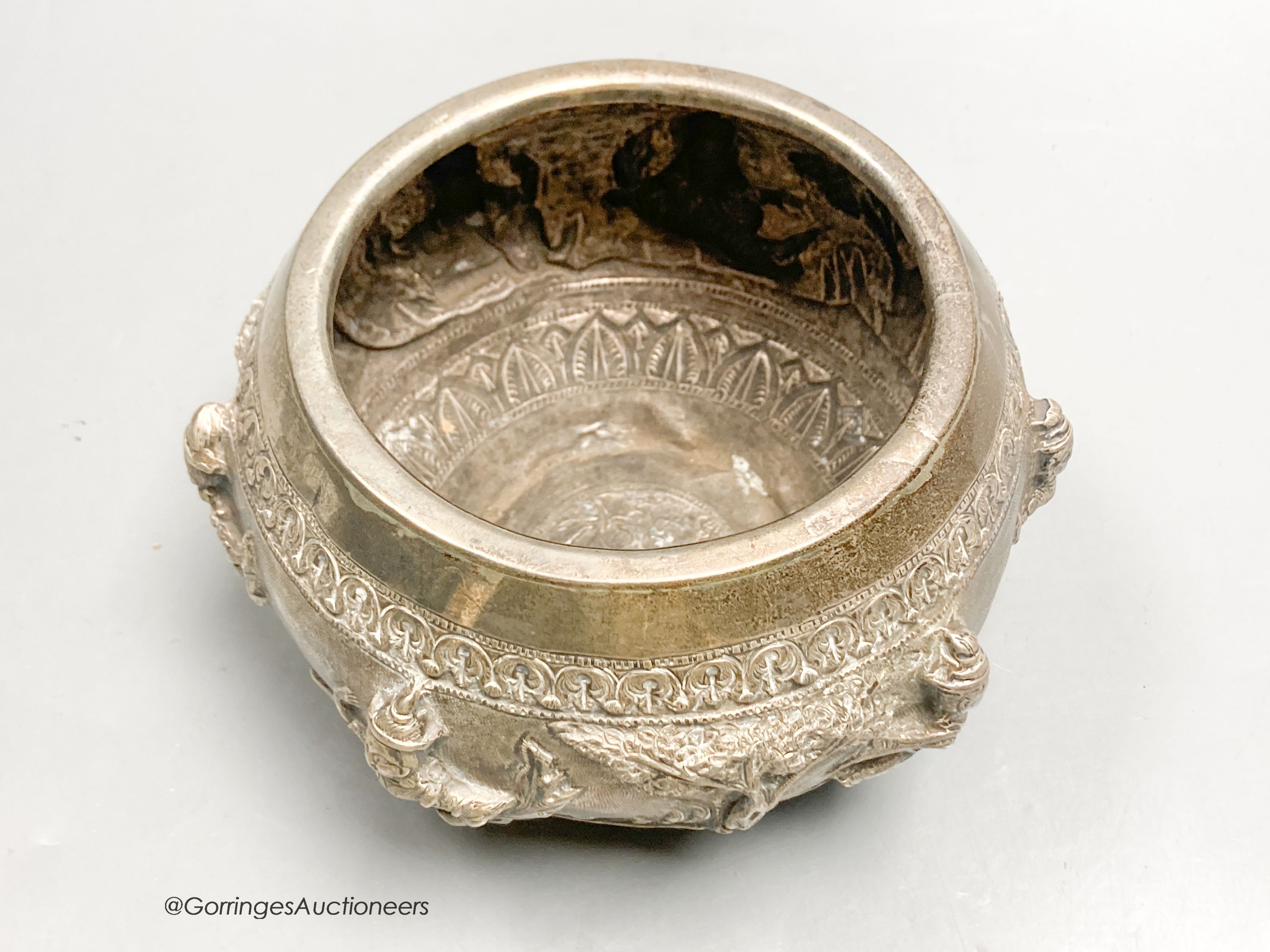 An Indian embossed white metal bowl, decorated with deities, height 8.5cm, 9oz.